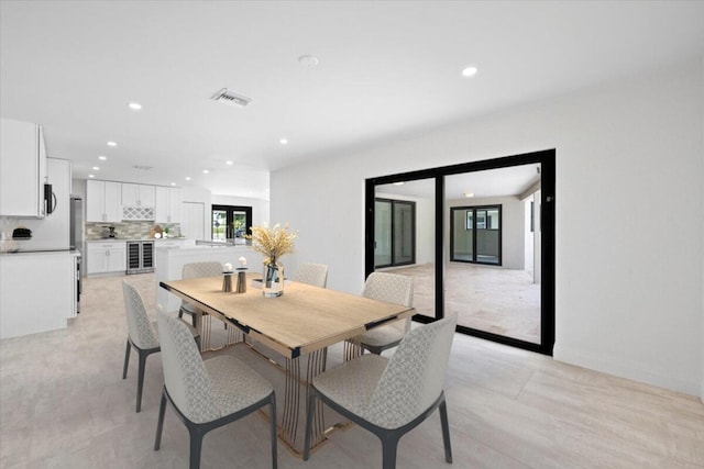 dining space featuring wine cooler and light hardwood / wood-style flooring