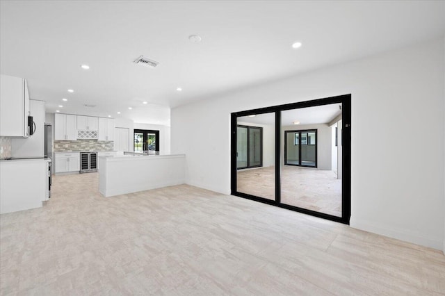 unfurnished living room with beverage cooler