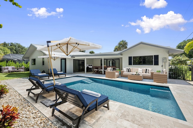 back of property with a fenced in pool, a patio area, and an outdoor hangout area