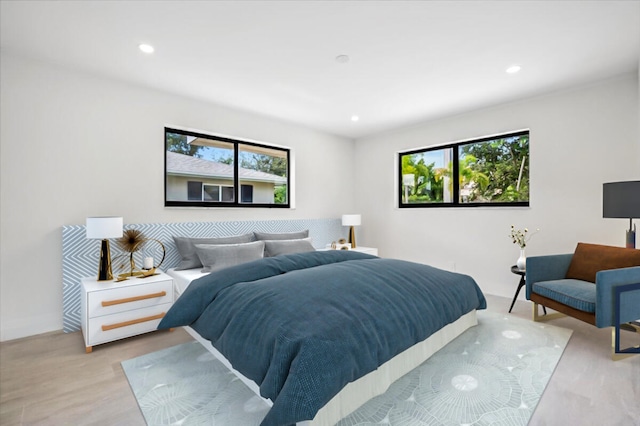 bedroom with multiple windows and light hardwood / wood-style floors