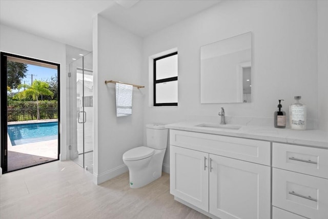 bathroom featuring toilet, vanity, a shower with shower door, and hardwood / wood-style flooring