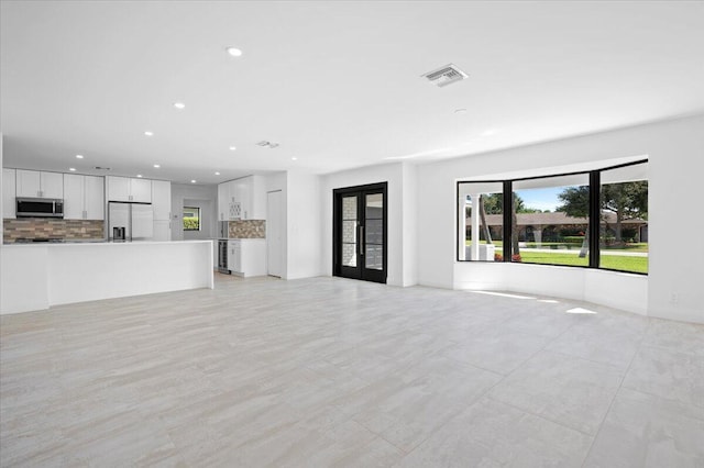 unfurnished living room featuring french doors