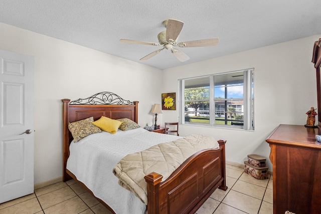 tiled bedroom featuring a textured ceiling and ceiling fan