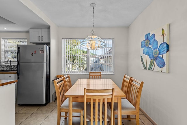 dining area with a notable chandelier, sink, and light tile patterned floors