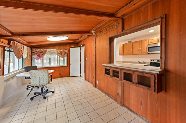 interior space featuring beam ceiling, wooden walls, stainless steel appliances, wooden ceiling, and light tile patterned floors