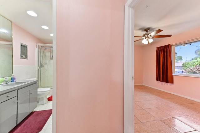 bathroom featuring tile patterned floors, toilet, a shower with shower door, vanity, and ceiling fan