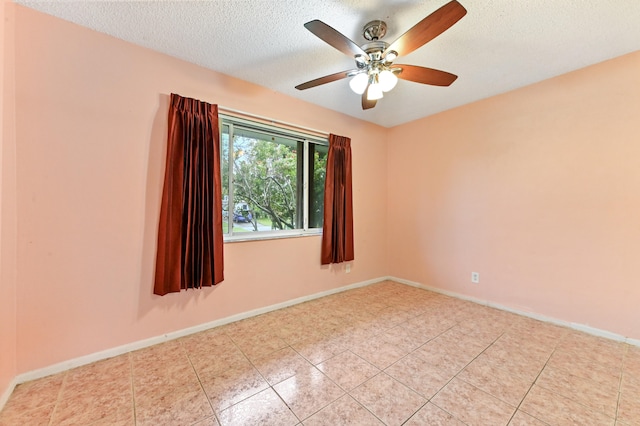 empty room with a textured ceiling, light tile patterned flooring, and ceiling fan