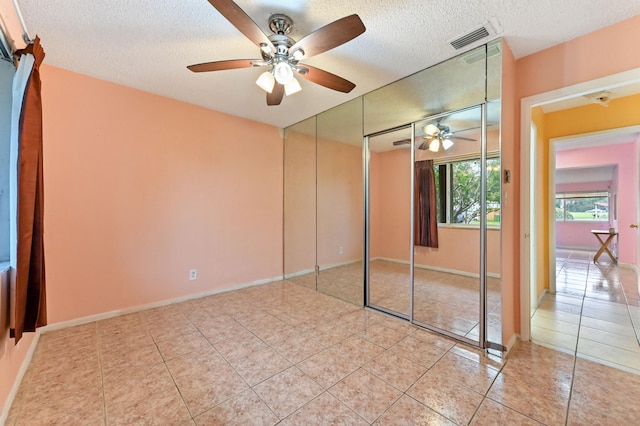 unfurnished bedroom with a closet, a textured ceiling, and ceiling fan