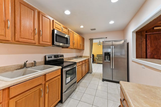 kitchen with sink, stainless steel appliances, and light tile patterned floors