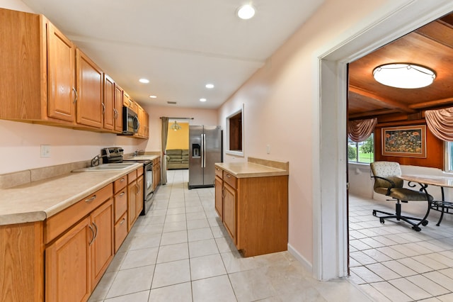 kitchen featuring sink, appliances with stainless steel finishes, light tile patterned floors, and beamed ceiling