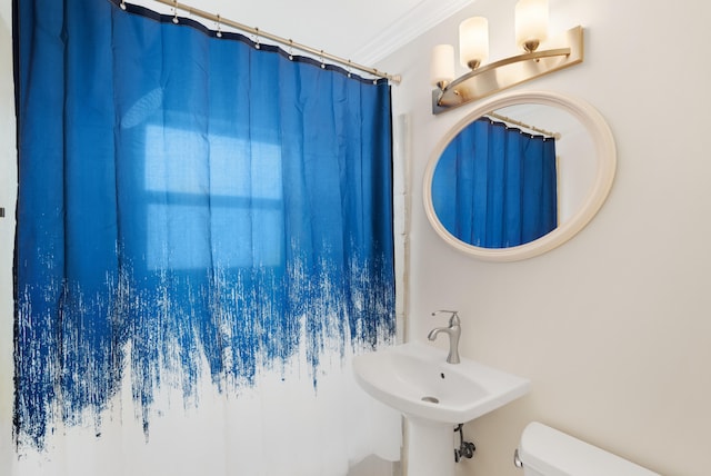 bathroom with ornamental molding, sink, and toilet