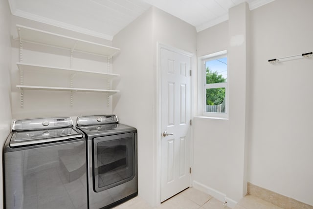 laundry area with washing machine and dryer, light tile patterned floors, and ornamental molding