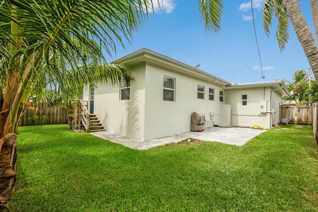 back of property with a patio area and a lawn