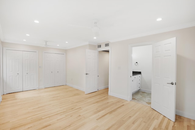 unfurnished bedroom featuring crown molding, ensuite bath, light wood-type flooring, and ceiling fan