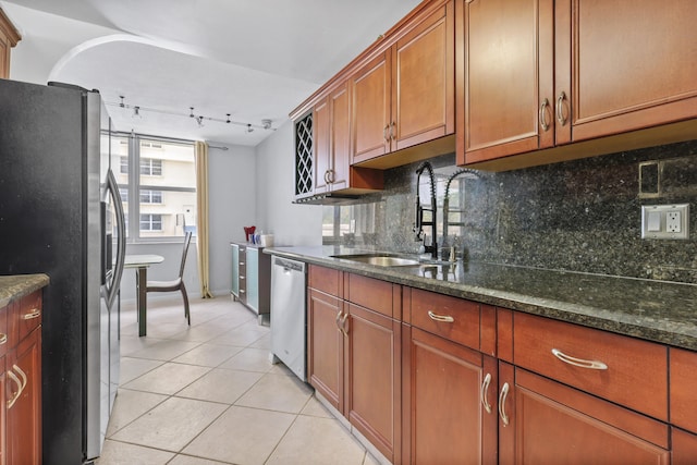 kitchen with rail lighting, stainless steel appliances, backsplash, light tile patterned floors, and sink