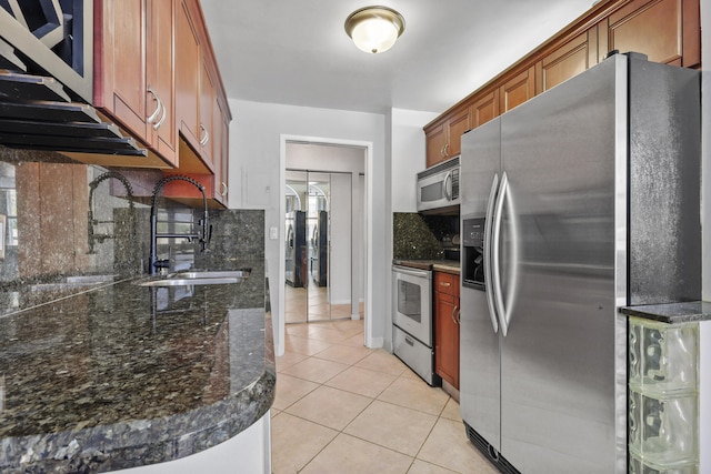 kitchen featuring appliances with stainless steel finishes, light tile patterned floors, and tasteful backsplash