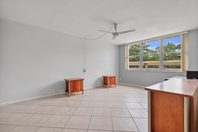 unfurnished office with ceiling fan and light tile patterned flooring