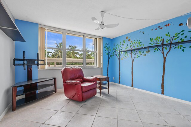 living area with ceiling fan and light tile patterned floors