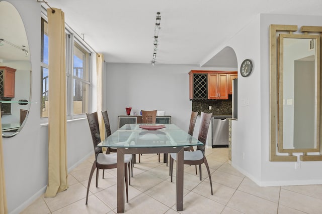 tiled dining space featuring rail lighting