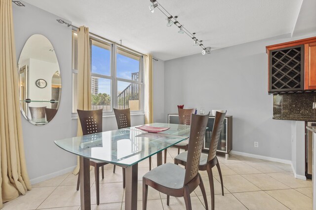 tiled dining area featuring a textured ceiling and track lighting