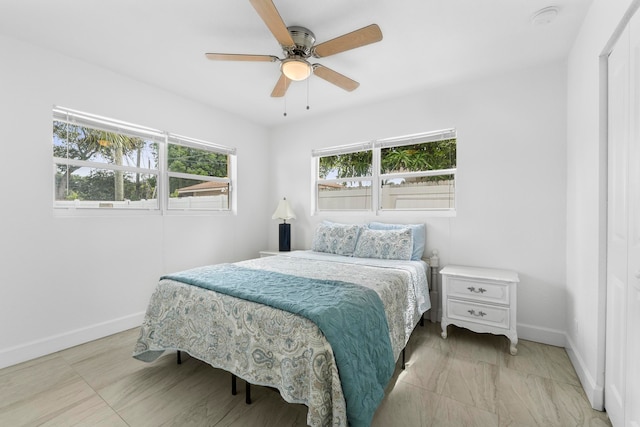 tiled bedroom featuring ceiling fan and multiple windows