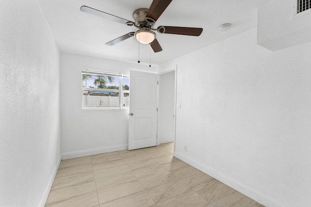 tiled empty room featuring ceiling fan