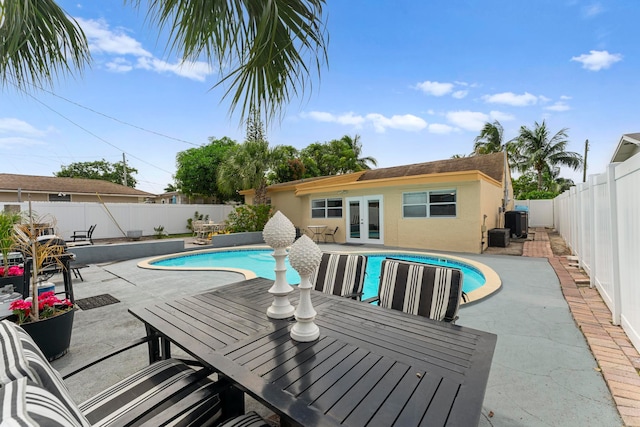 view of pool with central air condition unit, french doors, and a patio