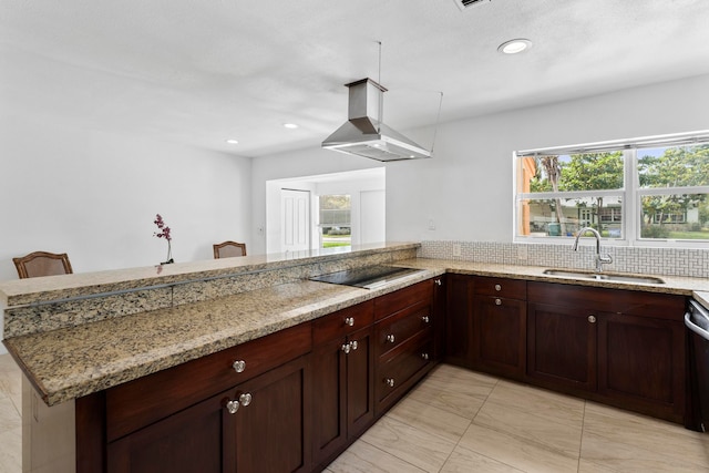 kitchen featuring island exhaust hood, sink, plenty of natural light, and light stone countertops