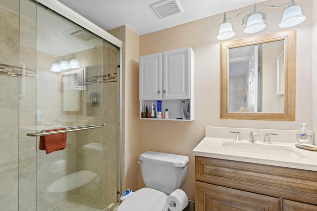 bathroom featuring vanity, toilet, and an enclosed shower