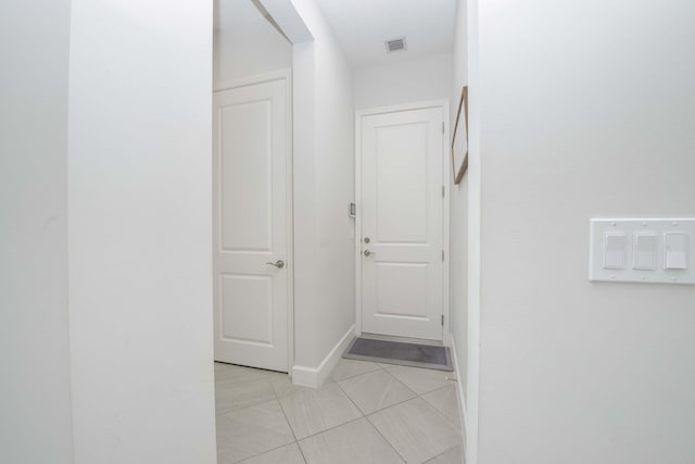 hall featuring light tile patterned floors