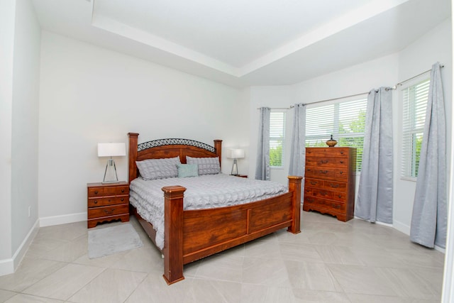 tiled bedroom featuring a tray ceiling