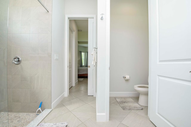 bathroom featuring tiled shower, toilet, and tile patterned floors