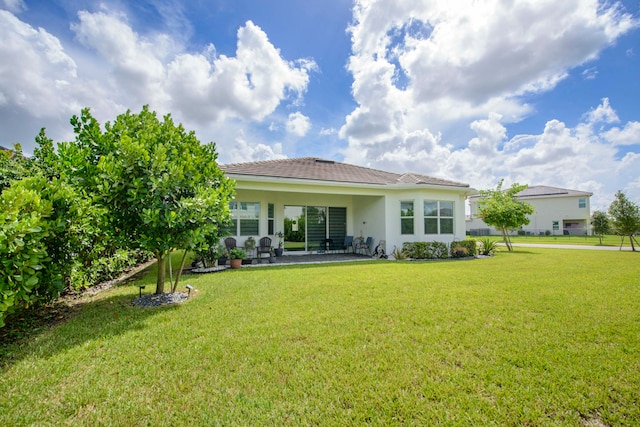 back of property featuring a patio area and a yard