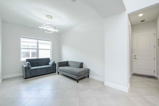 living room featuring light tile patterned flooring and an inviting chandelier