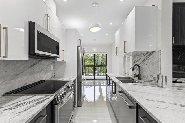 kitchen featuring appliances with stainless steel finishes, white cabinetry, wine cooler, backsplash, and light wood-type flooring