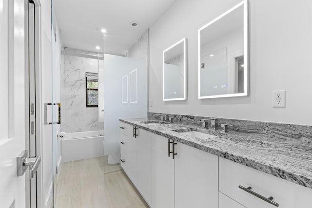 full bathroom with shower / bathtub combination, double vanity, a sink, and recessed lighting