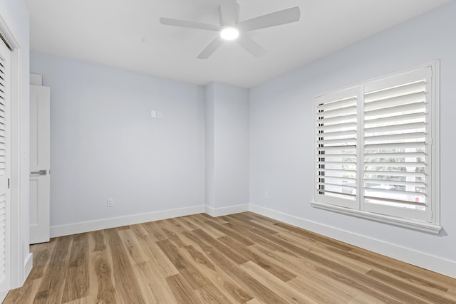 empty room featuring ceiling fan, light wood-style flooring, and baseboards