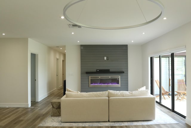 living room with hardwood / wood-style floors and a large fireplace