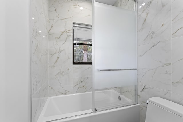 bathroom with toilet and bath / shower combo with glass door