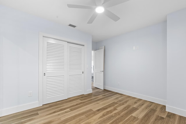 unfurnished bedroom featuring light wood-style floors, baseboards, visible vents, and a closet