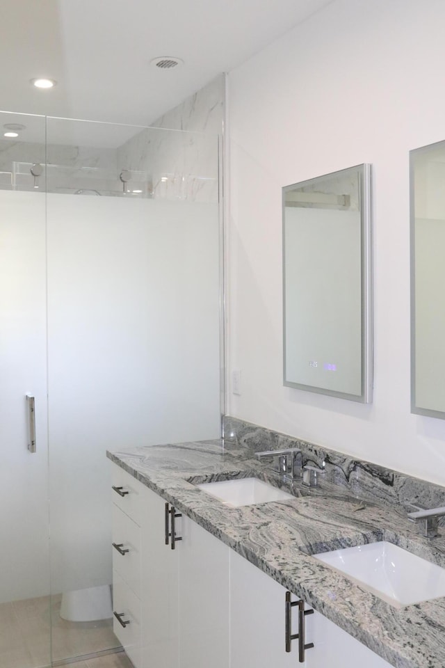 full bathroom featuring double vanity, recessed lighting, a sink, a walk in shower, and tile patterned floors