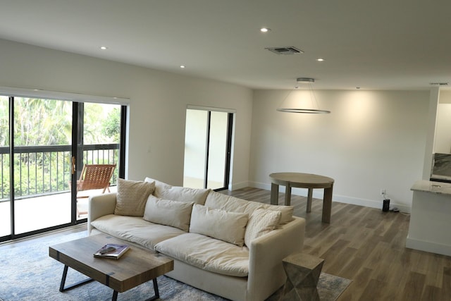 living room featuring baseboards, wood finished floors, visible vents, and recessed lighting