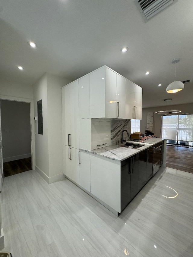 kitchen featuring electric panel, white cabinetry, a sink, and modern cabinets