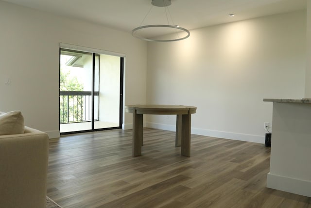 unfurnished dining area featuring dark wood-type flooring, recessed lighting, and baseboards