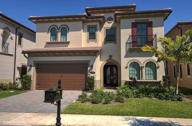 mediterranean / spanish house featuring a garage and a balcony