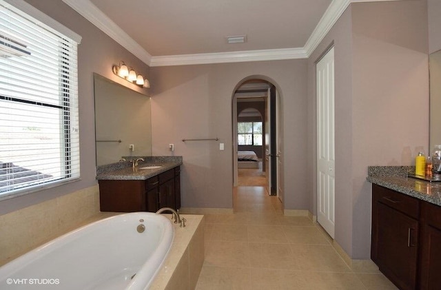 bathroom with tile patterned flooring, tiled tub, vanity, and ornamental molding