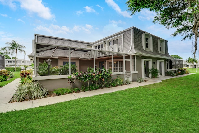 view of front of house with a balcony and a front yard