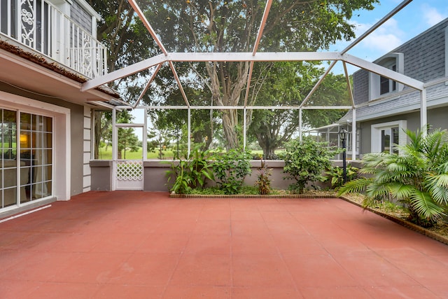 view of patio featuring glass enclosure