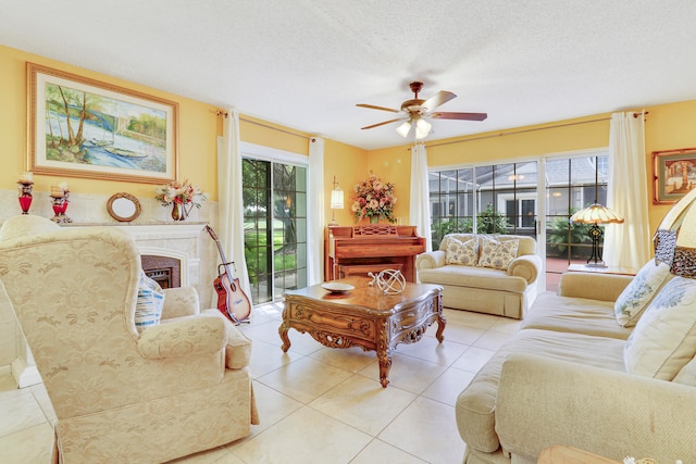 living room with ceiling fan, a textured ceiling, and light tile patterned floors