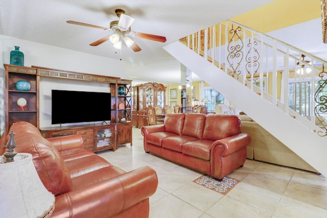 living room featuring a textured ceiling, light tile patterned floors, and ceiling fan